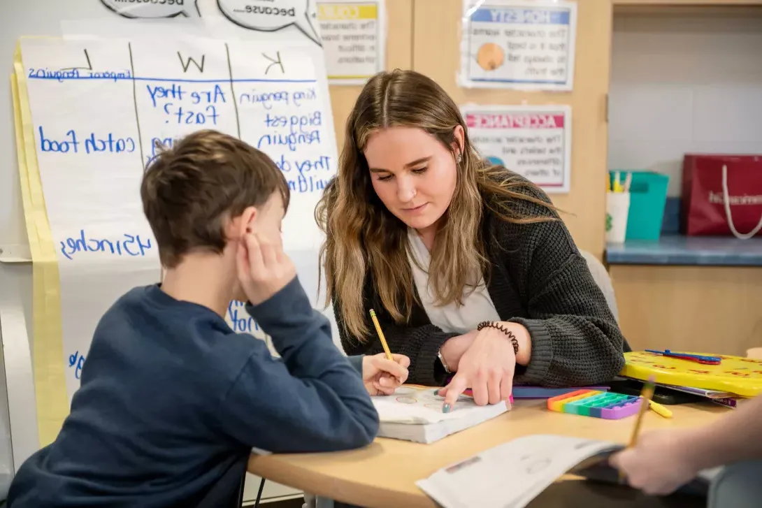 Elementary student working with aid